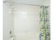 Traditional bathtub and shower combo featuring neutral tiling and a leaf-patterned curtain at 408 Yacht Harbor Ct # Share 2, Isle of Palms, SC 29451