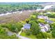 Aerial view of a beautiful home with a pool surrounded by mature trees and lush green landscaping at 4385 Ten Shillings Way, Ravenel, SC 29470