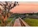 Scenic view of a wooden walkway surrounded by marsh grass leading to a home at sunset at 4385 Ten Shillings Way, Ravenel, SC 29470