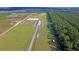 Aerial view of equestrian facility with barn, paddocks, training fields, and lush greenery at 4385 Ten Shillings Way, Ravenel, SC 29470