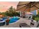 Inviting backyard pool area with lounge chairs, a fire pit, and lush landscaping at twilight at 4385 Ten Shillings Way, Ravenel, SC 29470