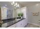 Bathroom featuring granite countertops, white cabinets, decorative plants, and large framed mirror at 4385 Ten Shillings Way, Ravenel, SC 29470