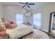 This bedroom features a ceiling fan, a television, two windows, and a decorative mirror at 4385 Ten Shillings Way, Ravenel, SC 29470