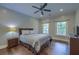 Comfortable bedroom with hardwood floors, ceiling fan, natural light, and neutral color palette for relaxation at 4385 Ten Shillings Way, Ravenel, SC 29470