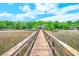 Picturesque dock extending over marshland leading to a covered pier, perfect for enjoying the natural surroundings at 4385 Ten Shillings Way, Ravenel, SC 29470
