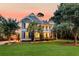 Beautiful two-story home with a double front porch, set on a well-maintained lawn surrounded by mature trees at 4385 Ten Shillings Way, Ravenel, SC 29470