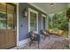 Charming front porch with comfortable seating, a swing, and brick flooring, perfect for enjoying the outdoors at 4385 Ten Shillings Way, Ravenel, SC 29470