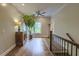 Well-lit upstairs hallway boasting hardwood floors and a staircase leading to other levels at 4385 Ten Shillings Way, Ravenel, SC 29470