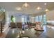 Open-concept kitchen showcasing stainless steel appliances, stone countertops, and seamless flow into the dining and living areas at 4385 Ten Shillings Way, Ravenel, SC 29470