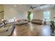 Spacious living room featuring hardwood floors, a coffered ceiling, and large windows offering ample natural light at 4385 Ten Shillings Way, Ravenel, SC 29470