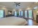 Bright main bedroom with tray ceiling, hardwood floors, ceiling fan, and large windows at 4385 Ten Shillings Way, Ravenel, SC 29470
