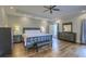 Well-lit main bedroom featuring hardwood floors, a ceiling fan, and plenty of storage at 4385 Ten Shillings Way, Ravenel, SC 29470