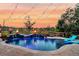 Inviting pool with a waterfall feature, spa, and fire pits, set against a picturesque sunset backdrop at 4385 Ten Shillings Way, Ravenel, SC 29470