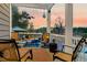 Charming outdoor porch with comfortable seating, decorative lighting, and beautiful views of the water and sky at 4385 Ten Shillings Way, Ravenel, SC 29470