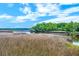 Scenic marsh landscape with a beautiful river view and dock house beneath a partly cloudy sky at 4385 Ten Shillings Way, Ravenel, SC 29470