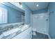 Well-lit bathroom featuring dual sinks with granite counters and a walk-in tiled shower at 4991 Lake Palmetto Ln, North Charleston, SC 29418