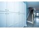 Hallway featuring a built-in white storage cabinet and a staircase with gray carpet and wood trim at 4991 Lake Palmetto Ln, North Charleston, SC 29418