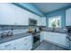 Modern kitchen with white cabinets, stainless steel appliances, and a gray countertop by the sink at 4991 Lake Palmetto Ln, North Charleston, SC 29418