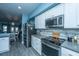 Kitchen with white cabinets, stainless steel appliances, gray counters, and an open view to the living spaces at 4991 Lake Palmetto Ln, North Charleston, SC 29418