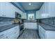 Modern kitchen boasts white cabinets, stainless steel appliances, a mosaic backsplash, and gray countertops at 4991 Lake Palmetto Ln, North Charleston, SC 29418