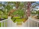 View of a lush, green backyard from the top of a white wooden staircase at 501 Joseph St, Charleston, SC 29412