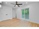 Bright bedroom features wood floor, a ceiling fan, balcony access, and double-door closets at 501 Joseph St, Charleston, SC 29412