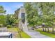 Angle view of the side of a two-story house with a front staircase and lush trees and vegetation around the lawn at 501 Joseph St, Charleston, SC 29412
