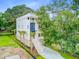 Stunning exterior view of a modern, multi-story home with a stairway, lush landscaping and a blue accent panel at 501 Joseph St, Charleston, SC 29412