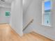 Well lit hallway with bright white walls and wood floors leading to the upper level at 501 Joseph St, Charleston, SC 29412