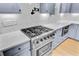 Close-up of a gas range and oven with custom range hood and white backsplash at 501 Joseph St, Charleston, SC 29412