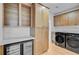 Well-organized laundry room with built-in cabinets, a wine cooler, and modern washer/dryer units at 501 Joseph St, Charleston, SC 29412