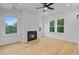 Bright living room featuring a fireplace, hardwood floors, large windows, and ceiling fan at 501 Joseph St, Charleston, SC 29412