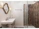 Bathroom with decorative mirror, pedestal sink, and glass shower stall with tile surround at 5065 Durant Ave, North Charleston, SC 29405