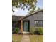 Charming gray brick home with a welcoming turquoise front door and mature trees at 5065 Durant Ave, North Charleston, SC 29405
