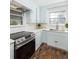 Bright kitchen with light blue cabinetry, modern stainless steel appliances, white countertops, and vintage-inspired flooring at 5065 Durant Ave, North Charleston, SC 29405