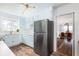 Kitchen with light blue cabinets, stainless steel appliances, and view of living room through archway at 5065 Durant Ave, North Charleston, SC 29405