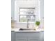 Close-up of kitchen sink with stainless steel faucet, white countertops, and subway tile backsplash at 5065 Durant Ave, North Charleston, SC 29405