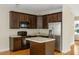 Well-equipped kitchen with dark wood cabinets, stainless steel appliances, and functional island at 5104 E Liberty Park Cir, North Charleston, SC 29405