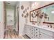Stylish bathroom with dual vanities, quartz countertops, a decorative mirror, and walk-in closet access at 593 Marsh Cove Cir, Summerville, SC 29486