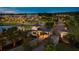 Aerial view of the neighborhood entrance featuring elegant gate houses, landscaping, and illuminated streets at twilight at 593 Marsh Cove Cir, Summerville, SC 29486