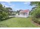Scenic backyard featuring a red-roofed garage, white picket fence, and lush green grass and foliage at 701 Hibbens Grant Blvd, Mount Pleasant, SC 29464