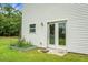 Back of a white house with a door to the yard, featuring a small garden area to the side at 717 Butter Rd, Bonneau, SC 29431