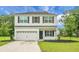 Two-story home boasts white siding, black shutters, and attached garage surrounded by lush greenery at 717 Butter Rd, Bonneau, SC 29431