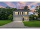 Two-story home with white siding, black shutters, a two-car garage, and a well-manicured front lawn at 717 Butter Rd, Bonneau, SC 29431