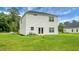 Rear exterior of a white two-story home showcasing a well-manicured lawn and access to the backyard at 717 Butter Rd, Bonneau, SC 29431