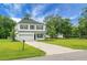 Two-story home boasts white siding, black shutters, and attached garage with a well manicured lawn at 717 Butter Rd, Bonneau, SC 29431