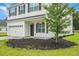 Close up of home's entrance features a well manicured lawn, mulch bed, and hanging plants at 717 Butter Rd, Bonneau, SC 29431