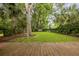 Backyard featuring mature trees, a swing, trampoline, and a well-manicured lawn at 732 Gate Post Dr, Mount Pleasant, SC 29464