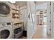 Functional laundry area with stacked washer and dryer, shelving, and easy access to the kitchen at 732 Gate Post Dr, Mount Pleasant, SC 29464