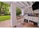Outdoor kitchen with bar seating, a grill, and views of the landscaped yard at 732 Gate Post Dr, Mount Pleasant, SC 29464